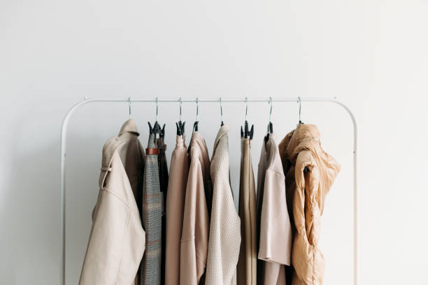 A minimalist clothing rack featuring neutral-colored garments for a capsule wardrobe.