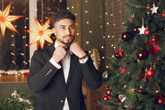 Man wearing a suit and tie at a Christmas party with colleagues